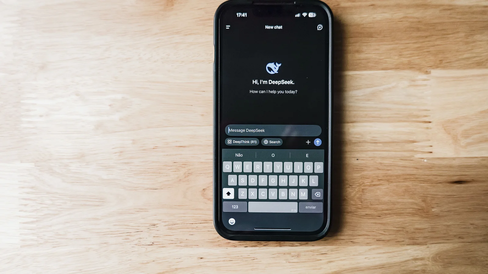 A smartphone on a wooden table showing an AI chatbot interface called DeepSeek.